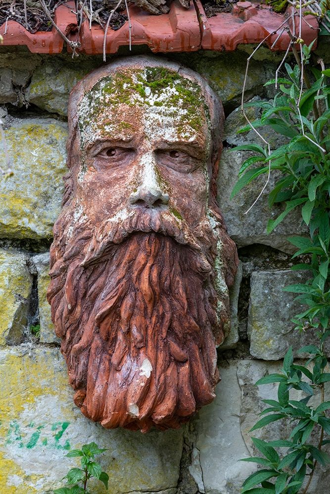 France-Giverny Stone face hanging on a stone wall